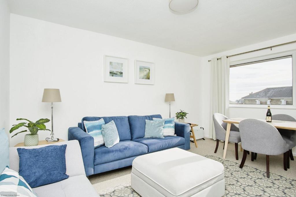 a living room with a blue couch and a table at Sundowners in Ryde