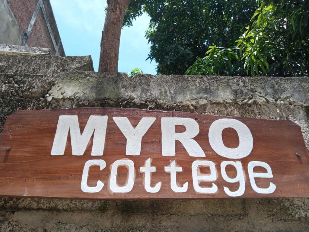 ein Schild für Myro-Kaffee auf einer Steinmauer in der Unterkunft Myro Cottage in Weligama