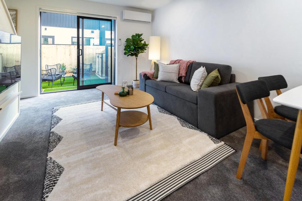 a living room with a couch and a table at Indulge in Christchurch Hagley Park 2 bed 2 bath in Christchurch