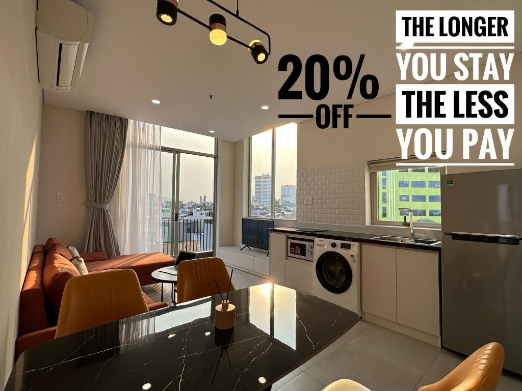 a kitchen and a living room with a microwave at Khe Suites Serviced Apartment - Han River in Danang