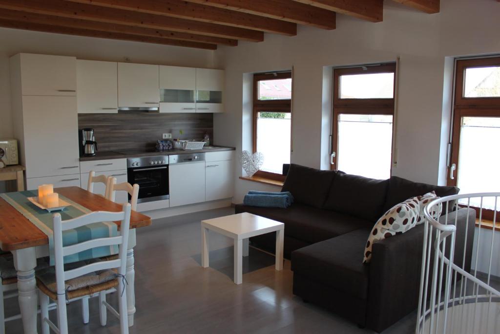 ein Wohnzimmer mit einem schwarzen Sofa und einem Tisch in der Unterkunft Ferienwohnung Morgentau in Kappel-Grafenhausen