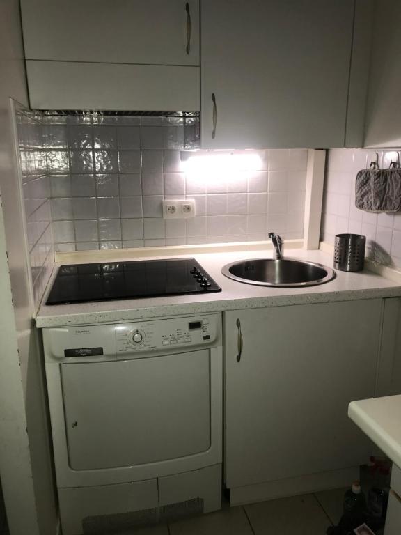 - une cuisine blanche avec évier et cuisinière dans l'établissement Appartamento in centro a Mentone vicino alla spiaggia Parcheggio privato INCLUSO!, à Menton