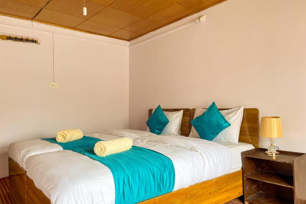 two beds in a room with blue pillows at Astrostays at Pangong in Spangmik