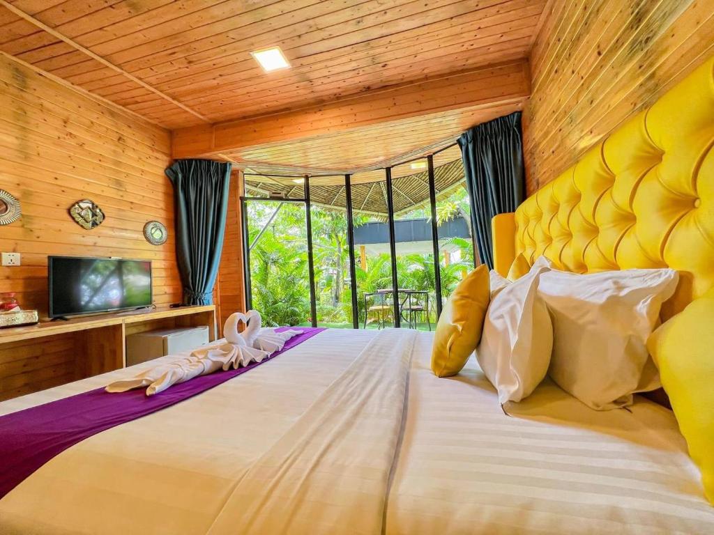 a bedroom with a large bed with a large window at Moly Resort in Kampot