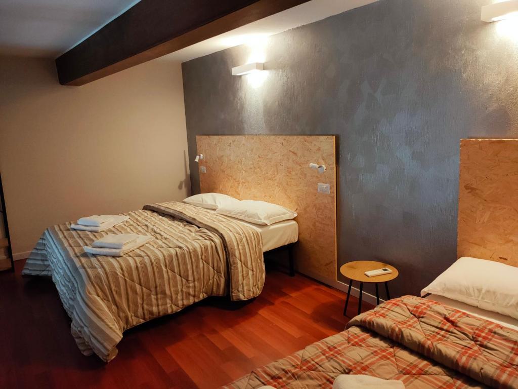 a hotel room with two beds and a table at APARTMENT STAZIONE in Bergamo