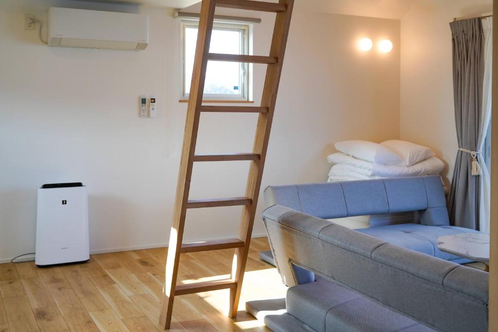 ein Wohnzimmer mit einer Leiter und einer Couch in der Unterkunft Beach SPA TSUDA 1 Uno in Sanuki