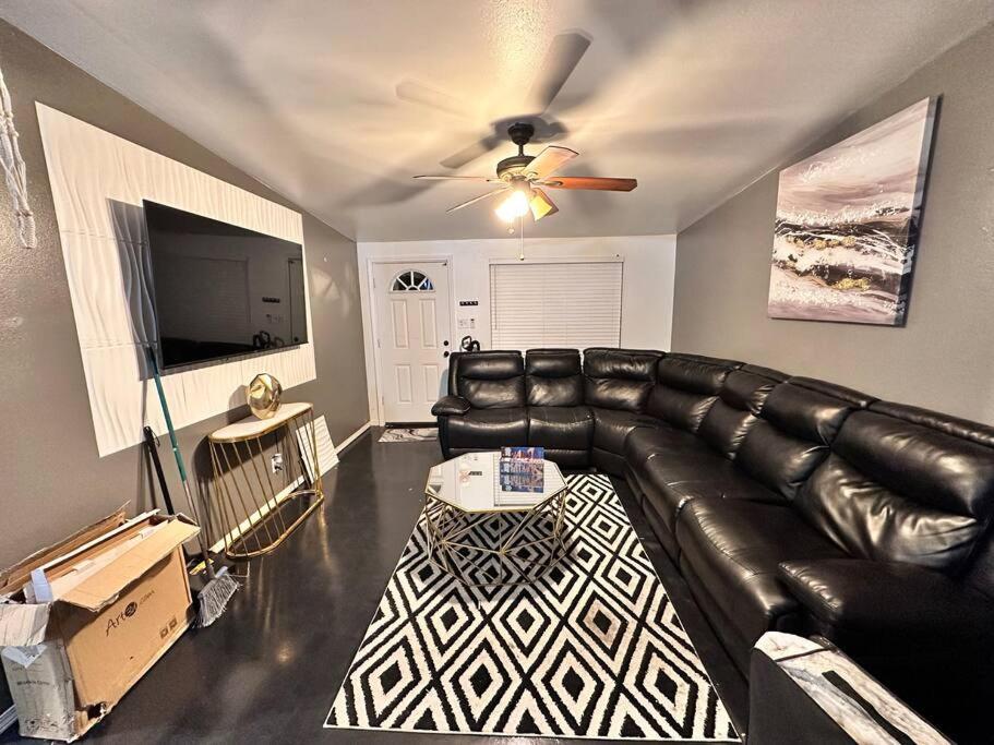 een woonkamer met een leren bank en een flatscreen-tv bij La casita Blanka in Las Cruces