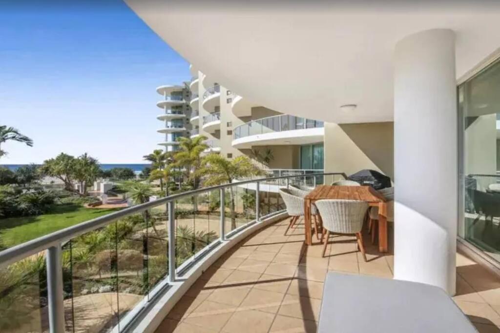 a balcony with a table and chairs and a view of the ocean at Palm Springs - Hosted by Burleigh Letting in Gold Coast