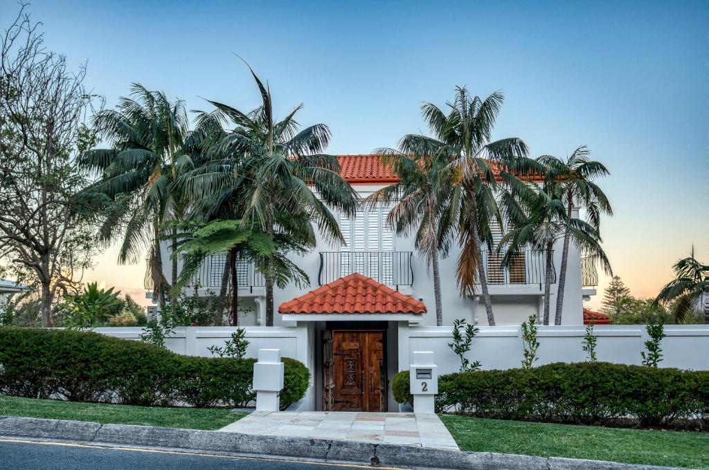 ein weißes Haus mit Palmen und einer Tür in der Unterkunft Villa Sunshine - Spectacular ocean views minutes to the sand in Sunshine Beach