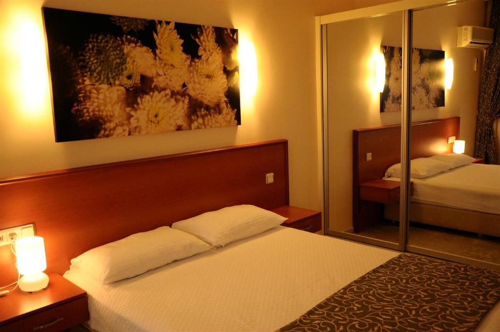 a hotel room with a bed and a mirror at Lord Hotel in Çeşme