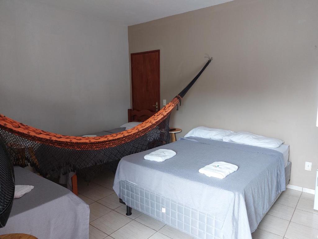 um quarto com duas camas e uma rede de descanso em Aloha Kite House em Lagoinha