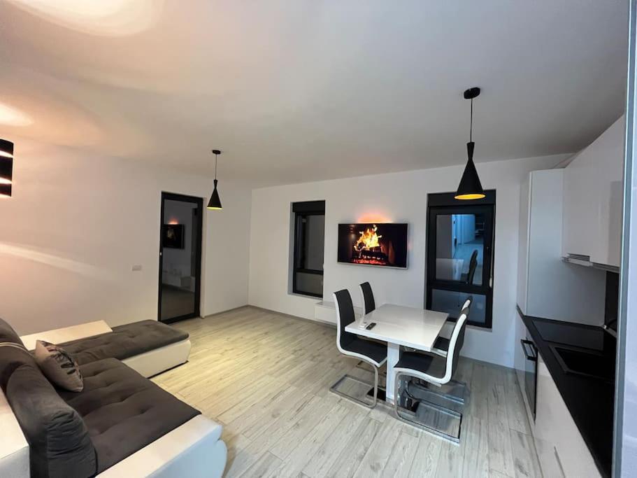 uma sala de estar com um sofá e uma mesa em Apartament cu 2 camere Giroc em Giroc