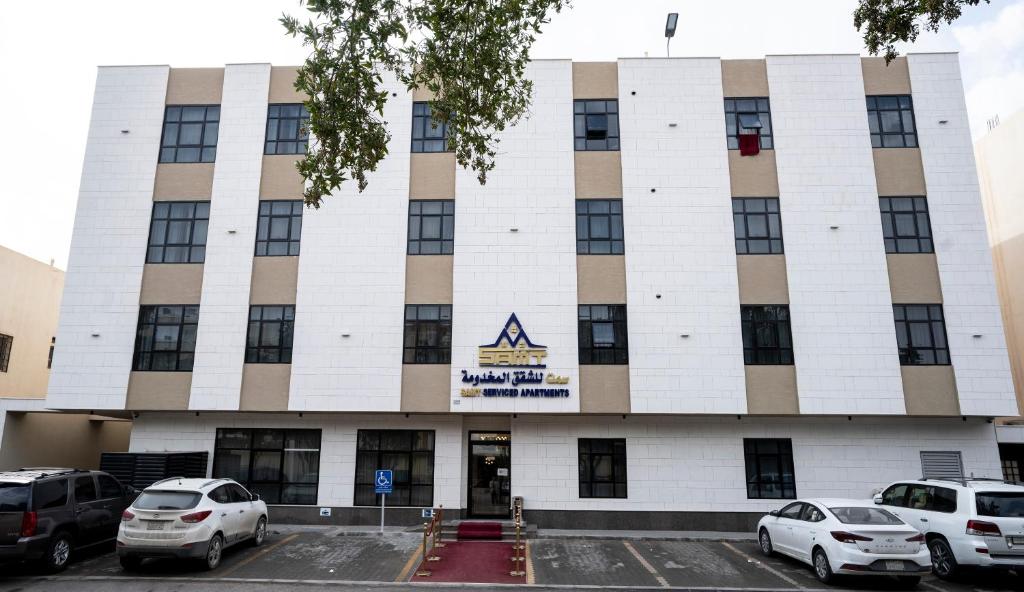 a building with cars parked in front of it at سمت الفيحاء للشقق المخدومة - Samt Al Fayhaa Serviced Apartments in Riyadh