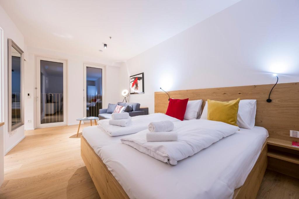 Luxury Suites Renngasse في فيينا: غرفة نوم بيضاء كبيرة مع سرير أبيض كبير