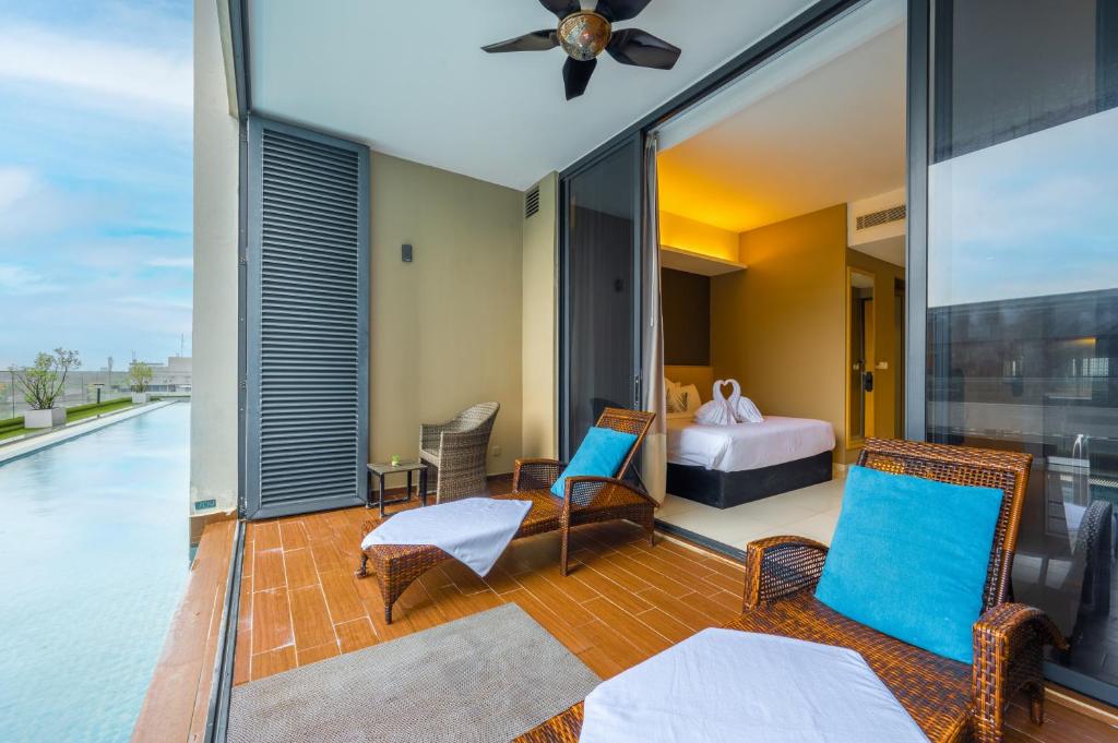 a room with a balcony with a bed and a bedroom at Greystone 99 Suites in Melaka