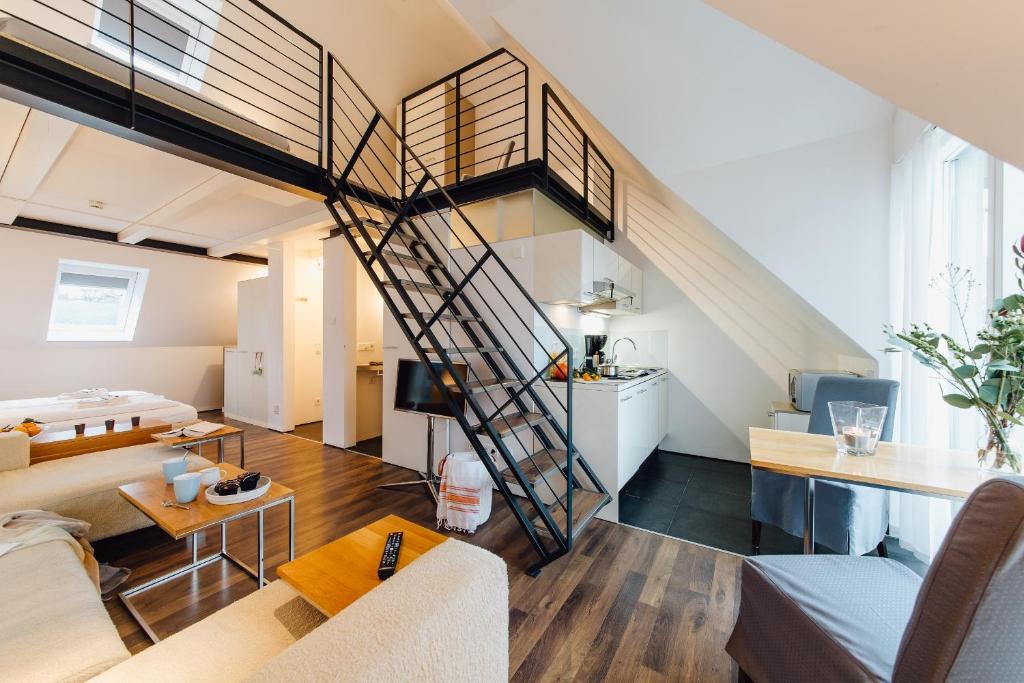 una sala de estar con una escalera de caracol en un loft en M2 Living Maisonette Apartment No 7, en Prerow