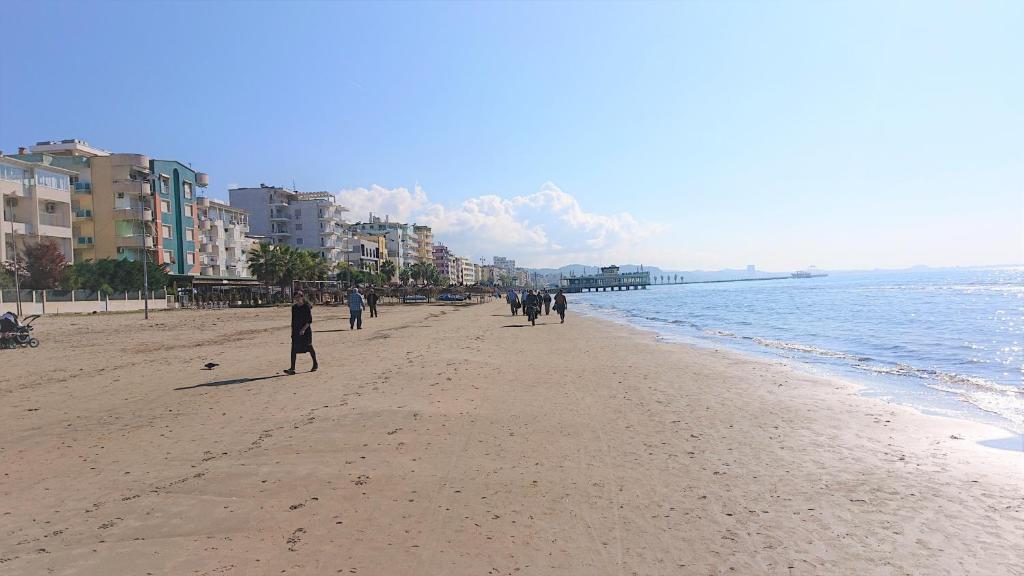 a group of people walking on the beach at Sunlit Coast Apartment Durrës in Durrës