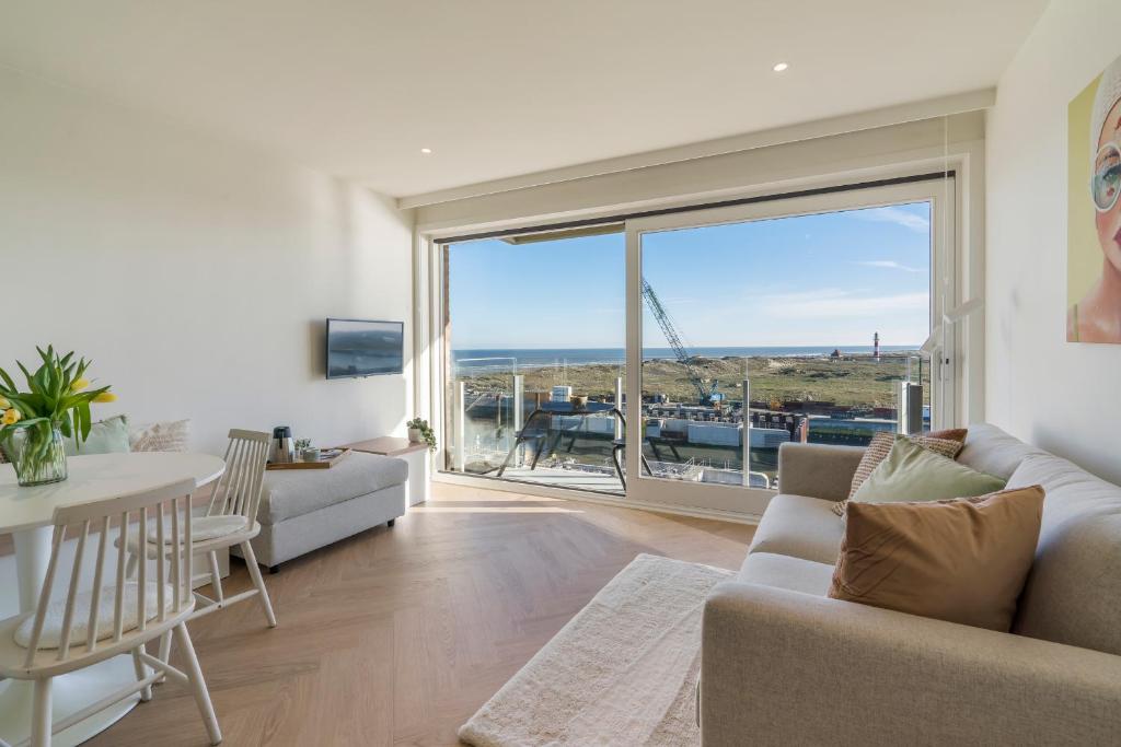 een woonkamer met een bank en een tafel bij Lighthouse studio with amazing & beautiful sea view in Nieuwpoort