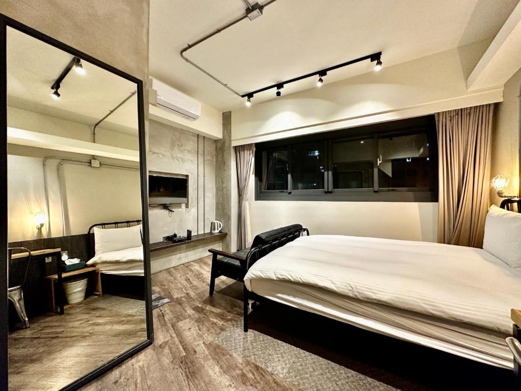 Habitación de hotel con cama y espejo en 小鹿 Homestay, en Taichung