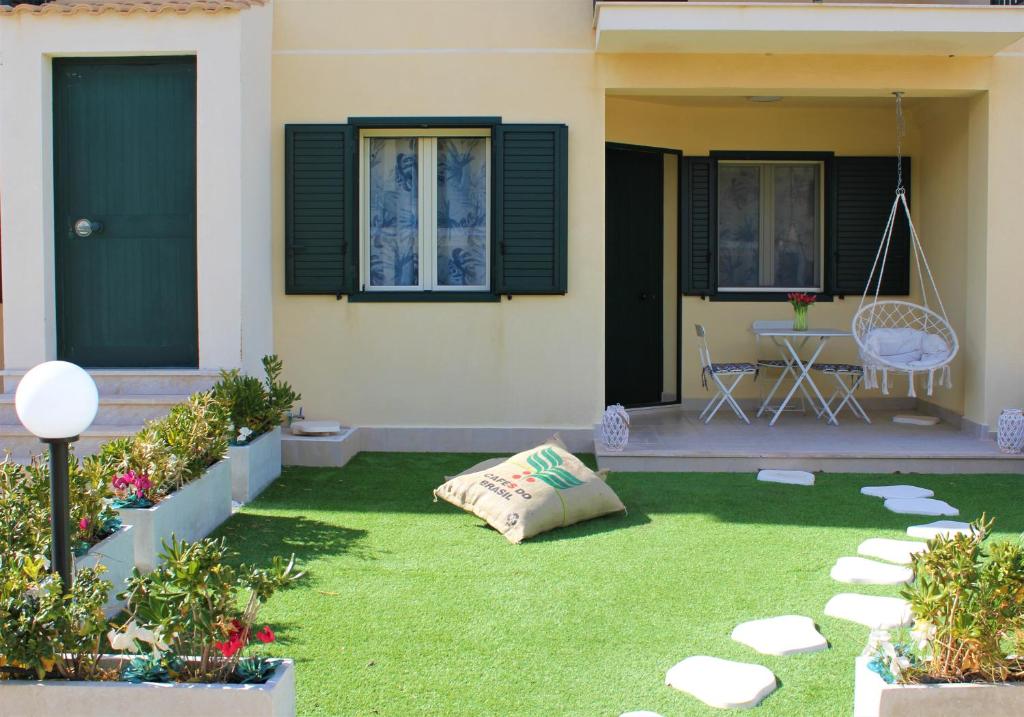 una casa con un cortile con erba verde di LA CASA DI CHLOE a Marzamemi