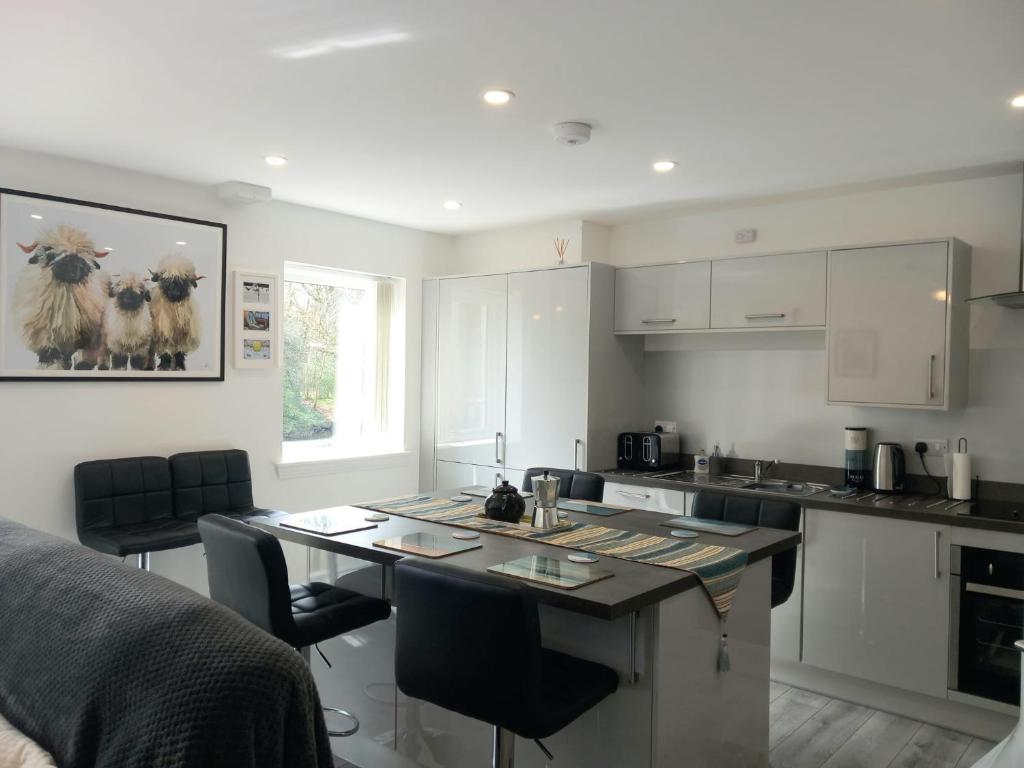 a kitchen with a table and chairs in a room at Beautiful Riverside Holiday Home in Callander