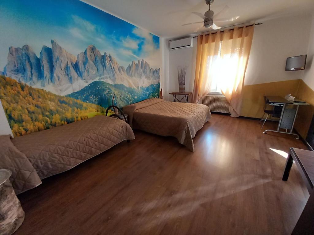 a bedroom with two beds and a mural of mountains at Bed & Breakfast Nettuno in Trento