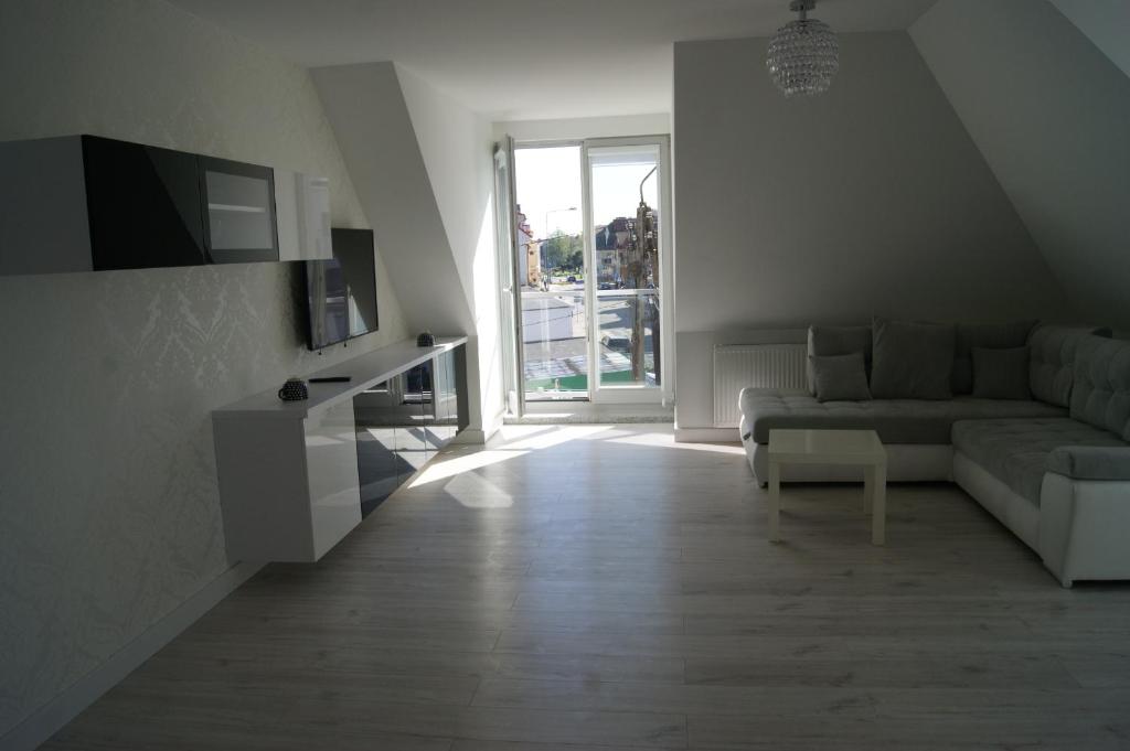 a living room with a couch and a tv at Kama Apartament Kamień Pomorski in Kamień Pomorski