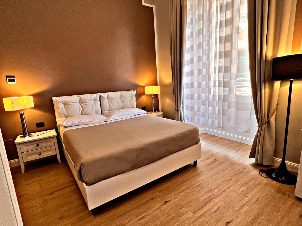 ローマにあるファビオ マッシモ ゲスト ハウスのベッドルーム1室(ランプ2つ、窓付)