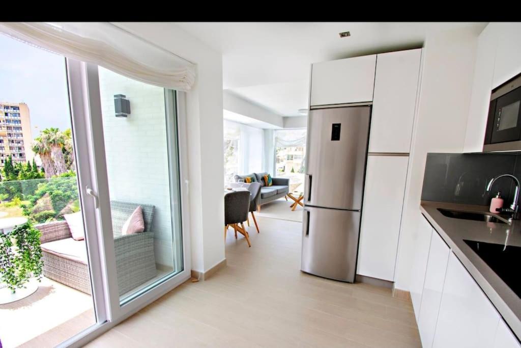 a kitchen with a stainless steel refrigerator and a living room at Modern 2 bedroom apartment in Benalmádena Costa in Benalmádena