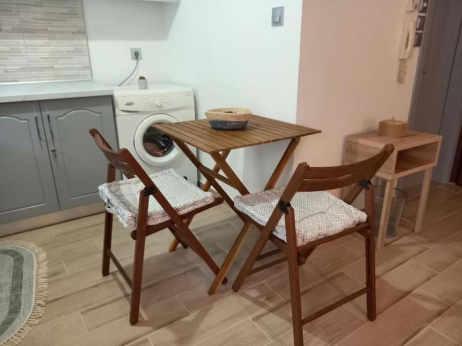 una cucina con tavolo, sedie e lavatrice di VagelisHome a Komotini