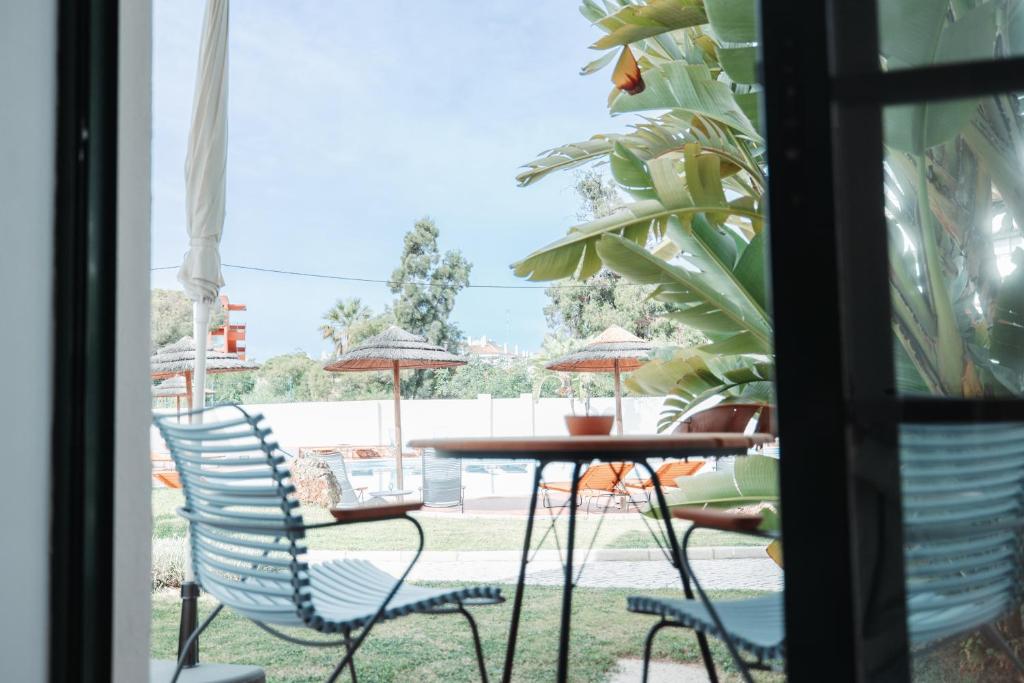 a table and chairs with umbrellas on a patio at Casa Velha Apartments - Adults friendly in Albufeira