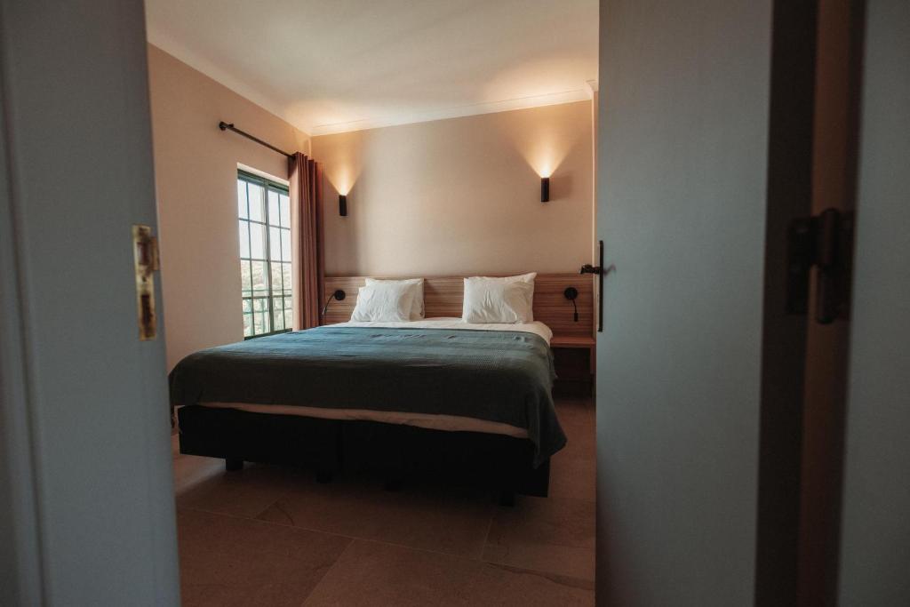 a bedroom with a bed and a window at Casa Velha Apartments - Adults friendly in Albufeira