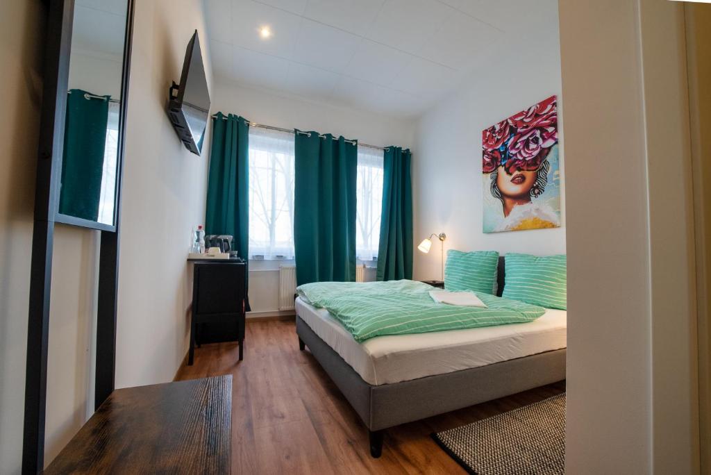 1 dormitorio con 1 cama con sábanas verdes en Löwen Unterkunft Langenhagen, en Hannover