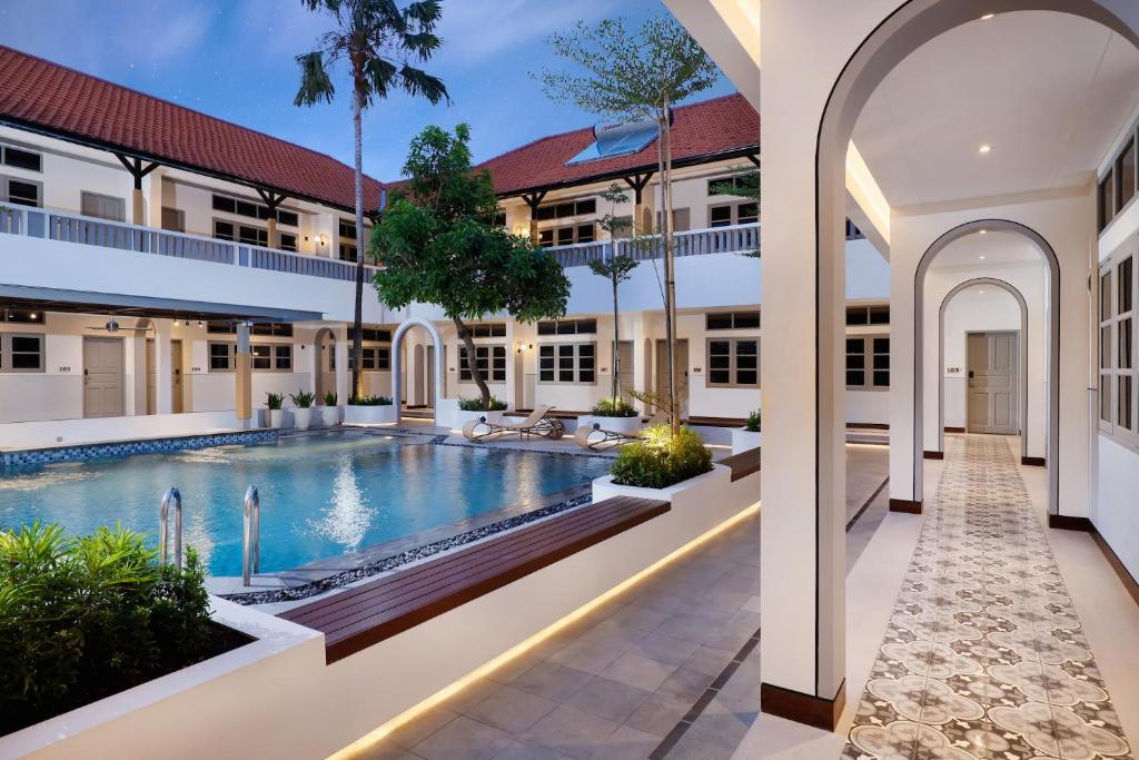 an exterior view of a building with a swimming pool at The Mahata in Legian