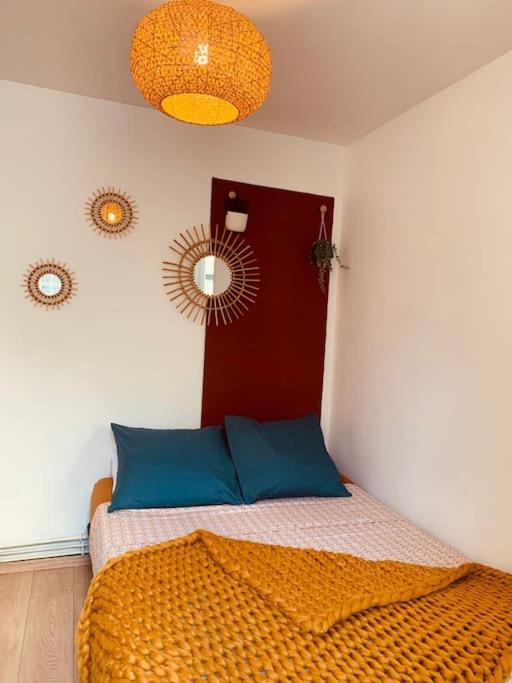 sypialnia z łóżkiem z niebieskimi poduszkami i lustrem w obiekcie Tiny81 cozy city break appartment w mieście Clichy