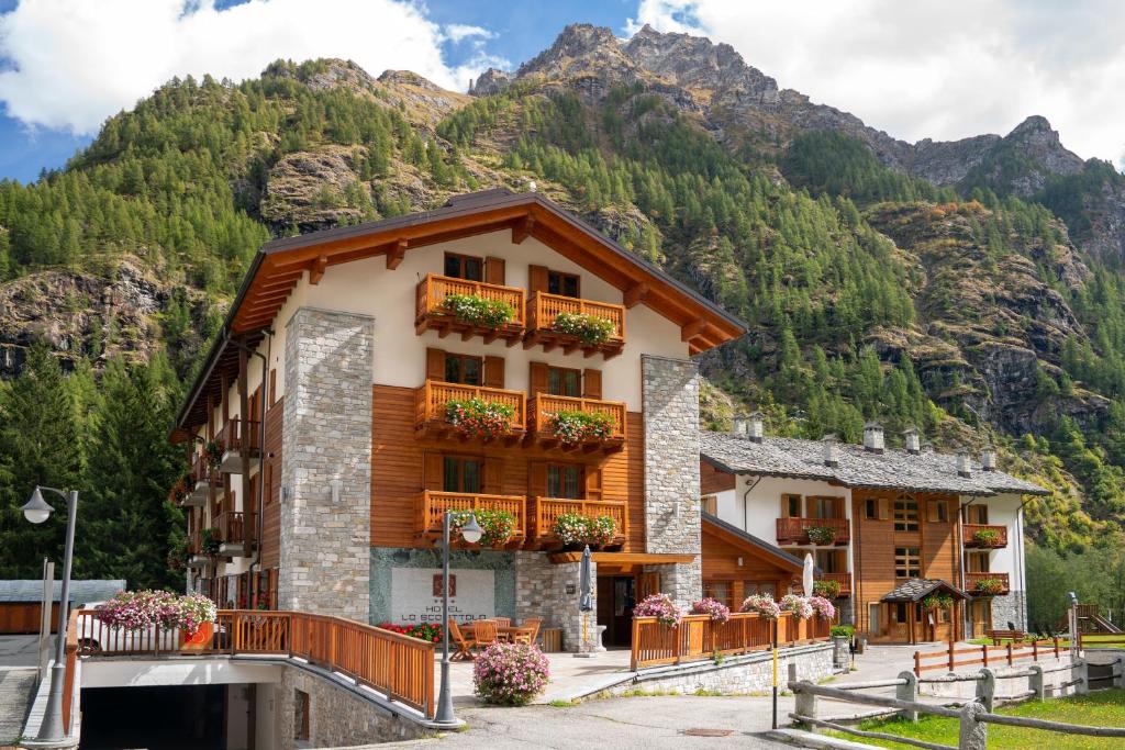 un edificio di fronte a una montagna di Hotel Lo Scoiattolo a Gressoney-la-Trinité