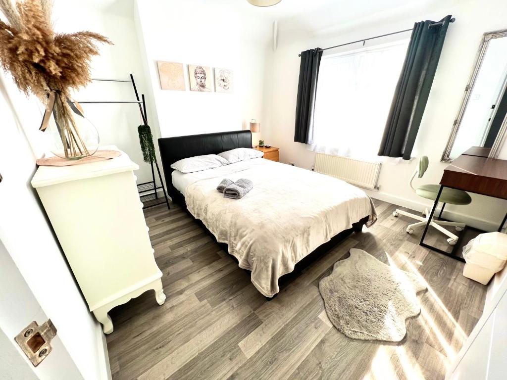 1 dormitorio con cama, escritorio y ventana en Beautiful Double Room for One Person, en Hither Green