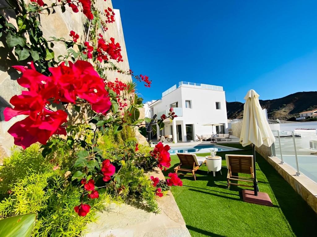 a garden with red flowers on the side of a building at Escape to paradise luxury Poolvilla with ocieanview near Amadores in Mogán