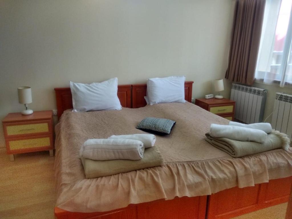 a bedroom with a large bed with towels on it at Kolimechkov Apartments Borovets in Borovets