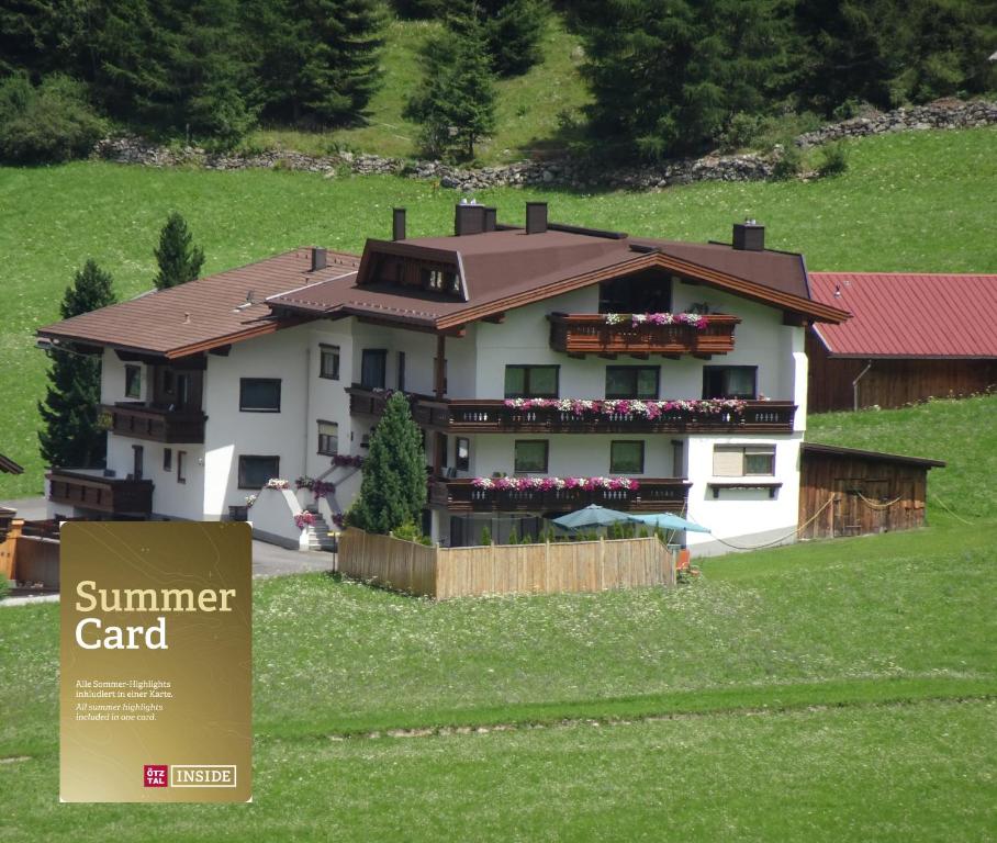 una casa en una colina con un cartel delante en Gästeheim Schmiedhof, en Sölden