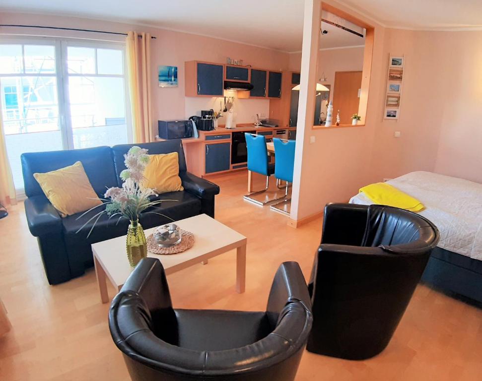 een woonkamer met een bank en een bed en stoelen bij Ostseestrand in Juliusruh