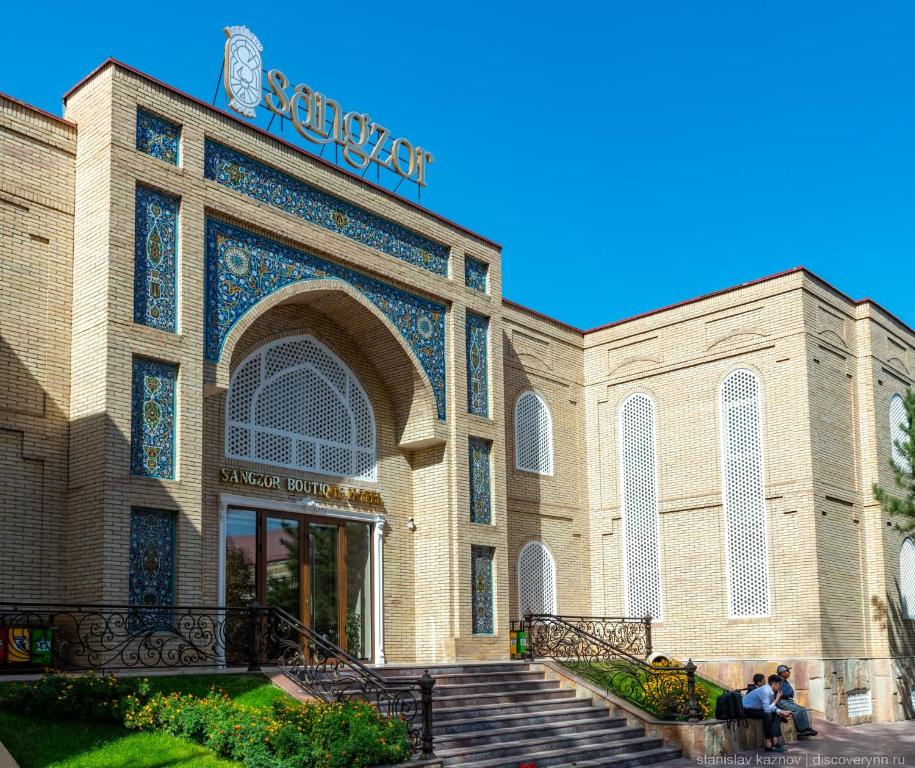 um edifício com pessoas sentadas à sua frente em Sangzor Boutique Hotel em Samarkand