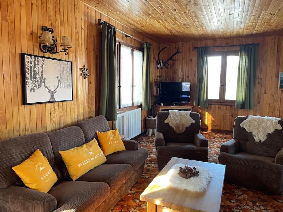 ein Wohnzimmer mit einem Sofa und 2 Stühlen in der Unterkunft Sirolane, chalet au bord des pistes au Sauze in Enchastrayes