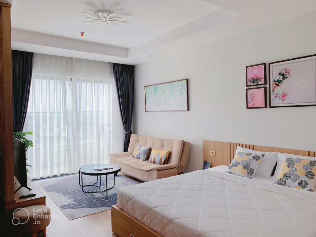 1 dormitorio con cama, sofá y TV en Căn hộ khách sạn gần biển TMS Luxury Quy Nhơn - Hanna House, en Quy Nhon