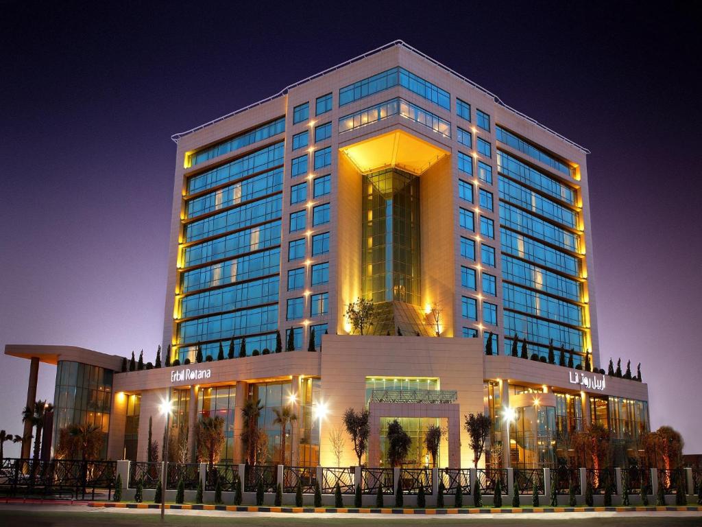 a large building with a lit up building at night at Erbil Rotana in Erbil