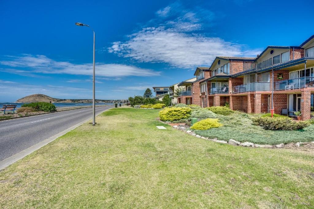 a house on the side of a road next to the ocean at By The Sea Beachfront Apartment Wifi in Encounter Bay