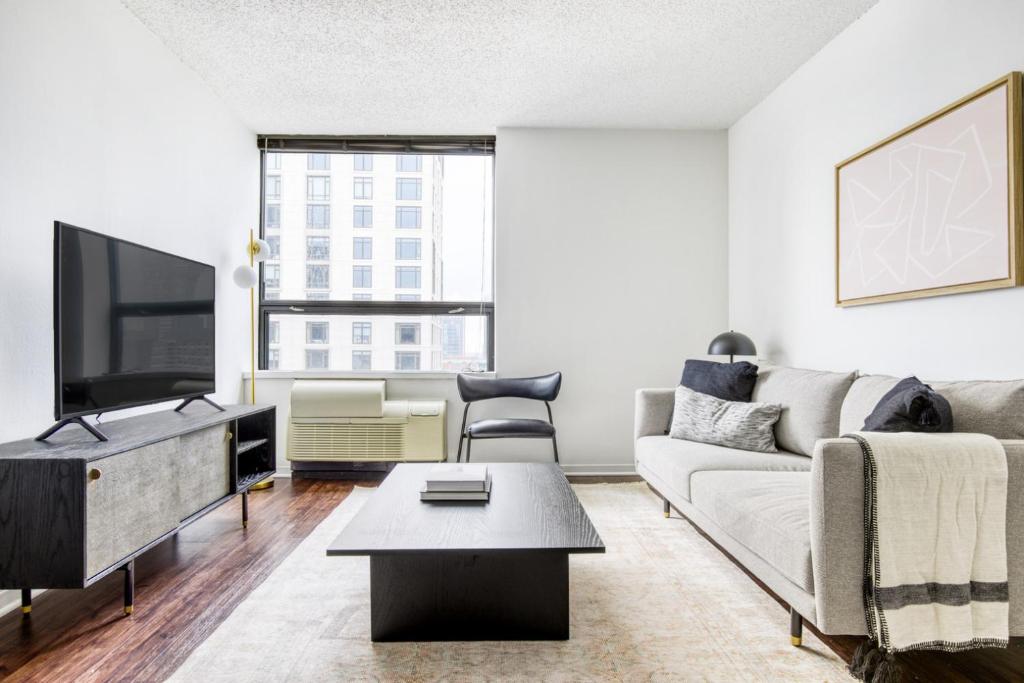 a living room with a couch and a tv at Streeterville 1BR w Gym Pool nr Navy Pier CHI-411 in Chicago