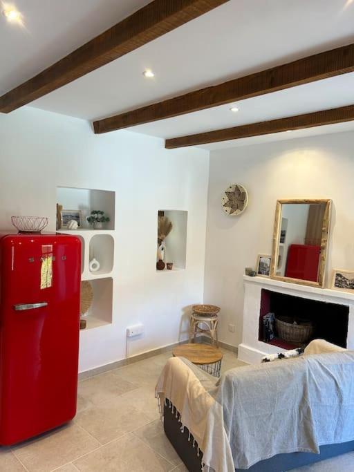 Charmante maison de village في أولميتو: غرفة بها ثلاجة حمراء ومرآة