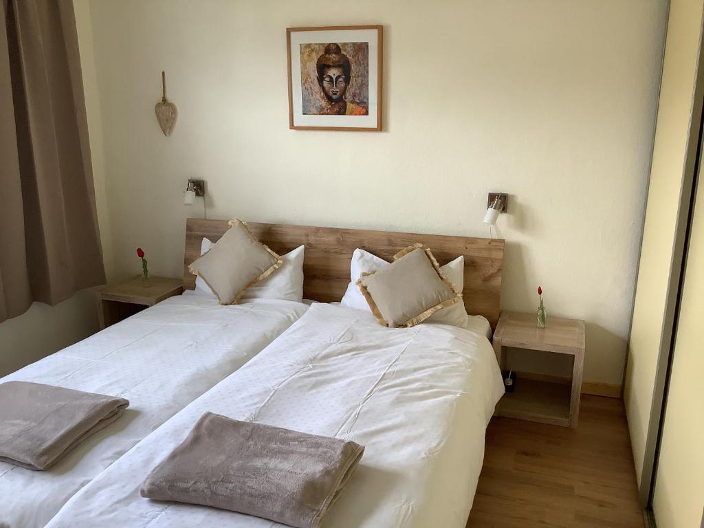 a bedroom with a large white bed with two pillows at Ferienwohnung SCHWARZACHHÖHE nur für Erwachsene in Wendelstein