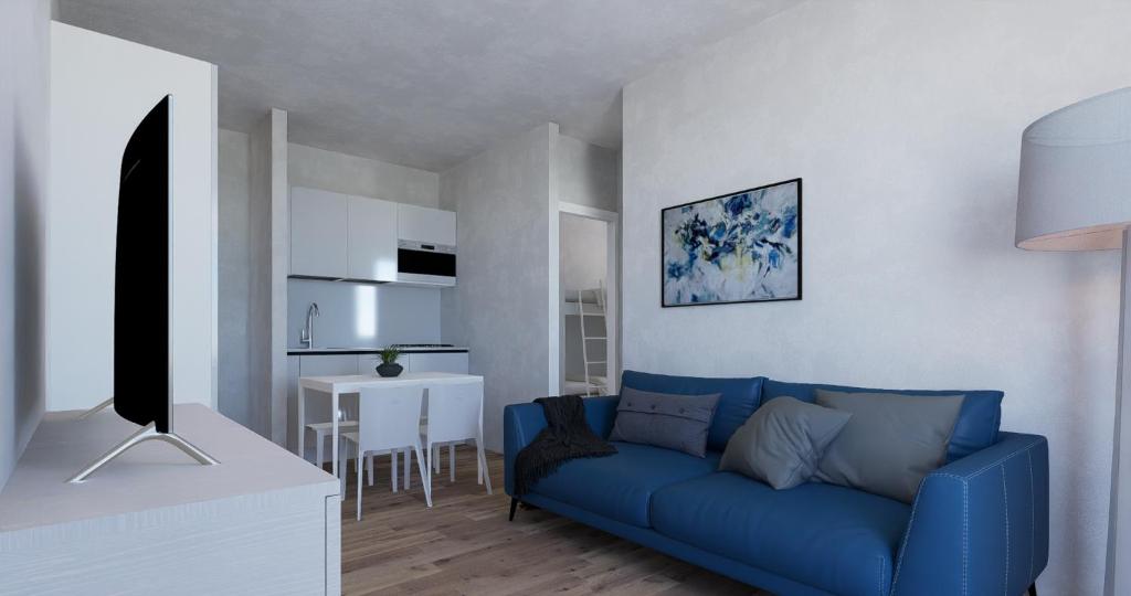 Residence Houston في ليدو دي يسولو: غرفة معيشة مع أريكة زرقاء وطاولة